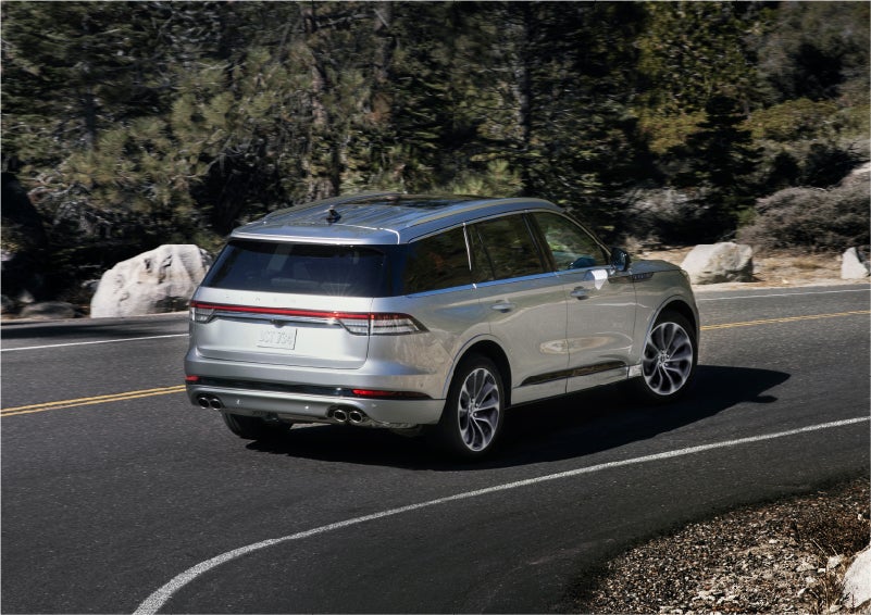 A 2023 Lincoln Aviator® Grand Touring model is shown being driven on a tight turn of a mountain road | Palmetto Lincoln in Charleston SC