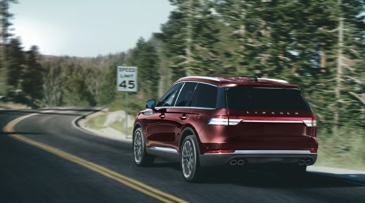 A 2024 Lincoln Aviator® SUV is being driven on a winding mountain road | Palmetto Lincoln in Charleston SC